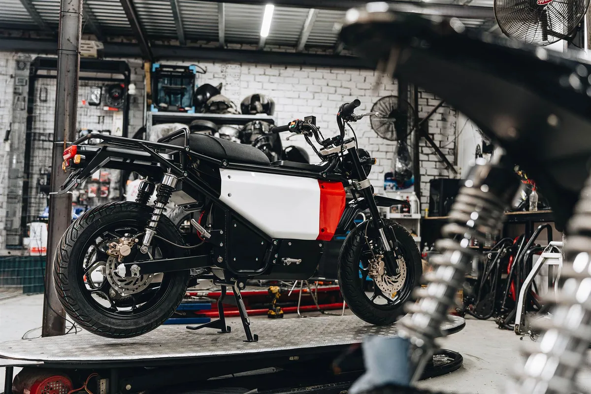 Volty U1 prototype on a workshop lift, side panel and rear rack fitted